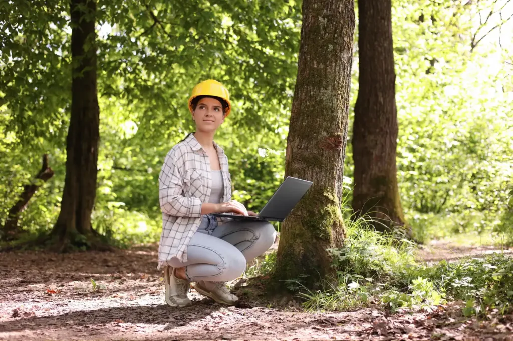 An ecologist writing up results on a laptop in the field